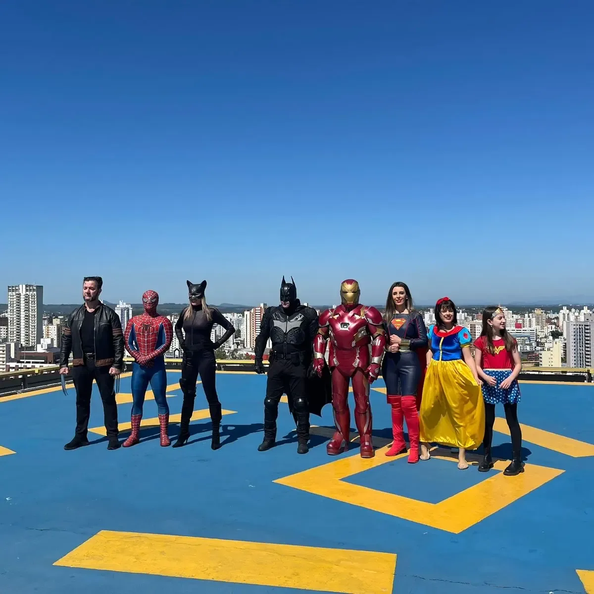 Equipe posando no terraço de um prédio, com vista da cidade