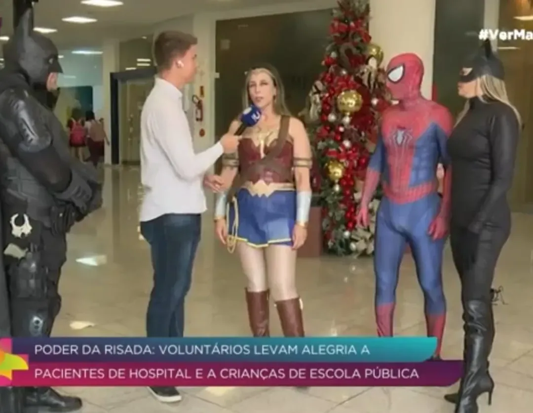 Voluntários sendo entrevistados por repórter de TV em shopping